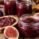 Selbstgemachte Feigenmarmelade im Glas mit frischen reifen Feigen