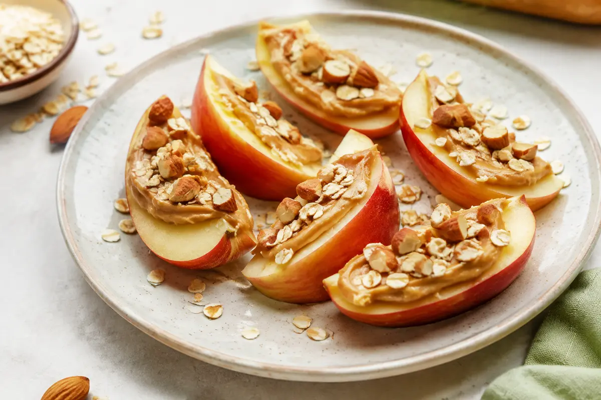 Ballaststoffreicher Snack aus Apfelspalten, Nussmus, Mandeln und Haferflocken
