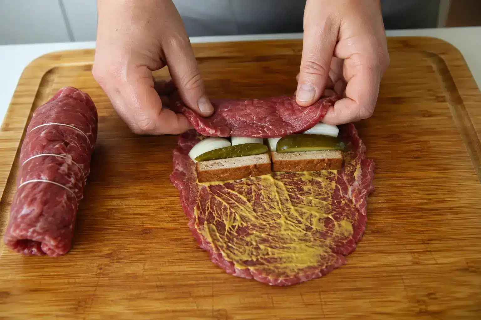 Rinderroulade mit Senf, Räuchertofu, Gurke und Zwiebel füllen und fest aufrollen