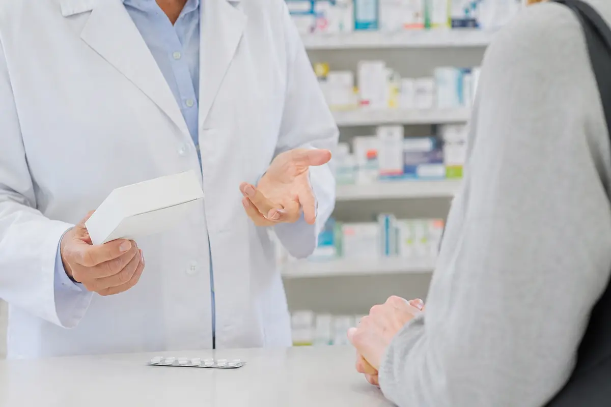 Apothekerin berät eine Kundin zu einem verschreibungspflichtigen Medikament