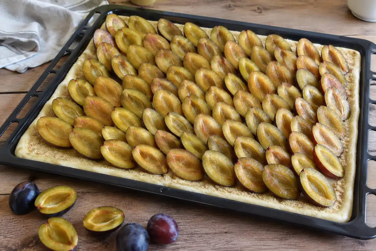 Zwetschgenkuchen auf dem Blech mit Zwetschgen belegen